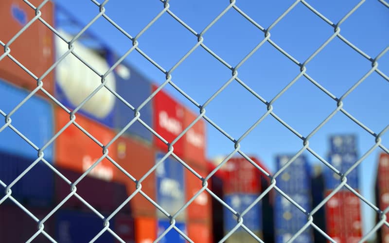 Container behind a wire mesh fence
